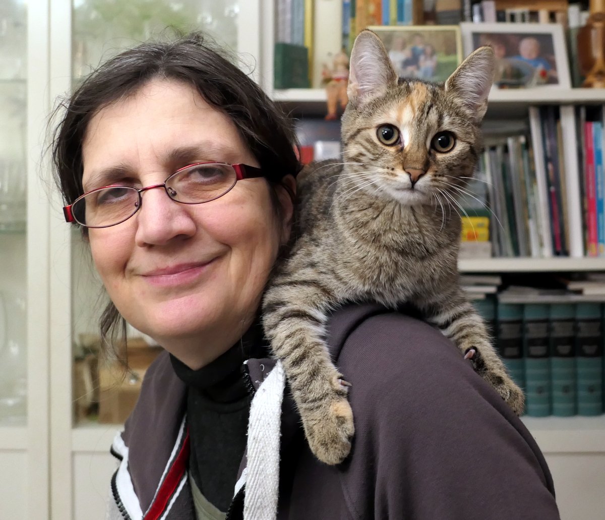 Katze Lilly liegt gemütlich auf den Schultern von Doris und schaut direkt in die Kamera. Ihr Blick ist aufmerksam und leicht verschmitzt, als wolle sie sagen: „Hier oben ist mein Lieblingsplatz.“ lilly-20251108